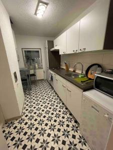 布倫瑞克的住宿－RobinsHomes-2023-Frisch renoviert in BS-Lehndorf，厨房配有白色橱柜和黑白瓷砖地板。
