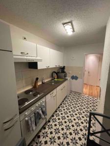 布倫瑞克的住宿－RobinsHomes-2023-Frisch renoviert in BS-Lehndorf，厨房配有白色橱柜,铺有黑白地板。