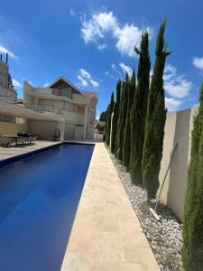 a swimming pool in front of a house with trees at Kosher Luxury villa - Raanana in Ra‘ananna