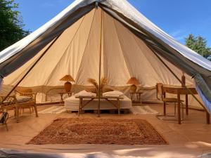 une grande tente avec une table et des chaises. dans l'établissement Bådsted Camping, à Gudhjem