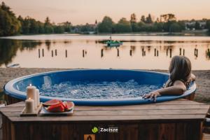 a young girl in a bath tub on a dock at Półwysep Zacisze - Tiny House Village in Przywidz