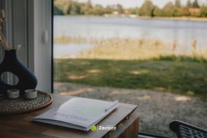 - une table avec une fenêtre donnant sur un lac dans l'établissement Półwysep Zacisze - Tiny House Village, à Przywidz