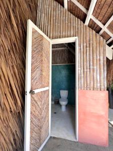 an open door to a bathroom with a toilet at Tropical Jungle Villa 5 min walk to Cloud 9 in General Luna +27 photos