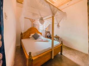 a bedroom with a wooden bed in a room at The Kichwa House in Kiwengwa