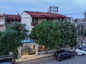 a building with two cars parked in front of it at Erifili Kallithea in Kallithea Halkidikis