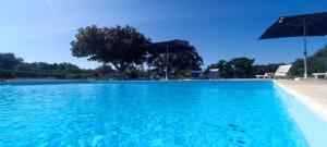 - une piscine d'eau bleue et 2 parasols dans l'établissement Quinta do Lagar, à Albufeira