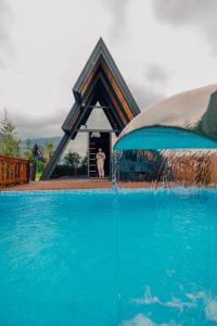 a man standing in front of a house with a swimming pool at Palm Bungalov Hotel in Kartepe