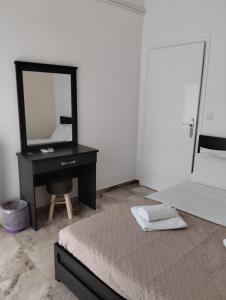 a bedroom with a bed and a desk with a mirror at Katerina Apartments in Kalamata