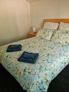 a bedroom with a bed with two blue towels on it at Willows Cottage in Warburton