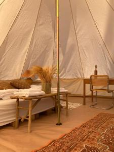 - une chambre avec une tente dotée d'un lit et d'une table dans l'établissement Bådsted Camping, à Gudhjem