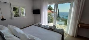 a bedroom with a bed and a large window at Les Maisonettes in Kokkari
