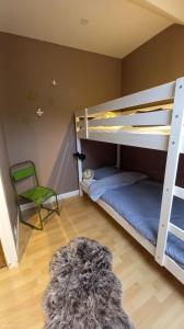 - une chambre avec 2 lits superposés et une chaise verte dans l'établissement Charmante maison bourguignonne avec grand jardin et parking, à Montbard