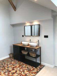 La salle de bains est pourvue de 2 lavabos et d'un miroir. dans l'établissement Charmante maison bourguignonne avec grand jardin et parking, à Montbard