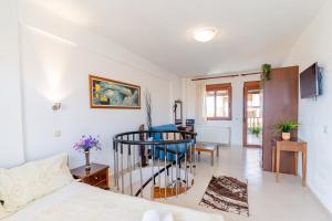a living room with a bed and a spiral staircase at Erifili Kallithea in Kallithea Halkidikis