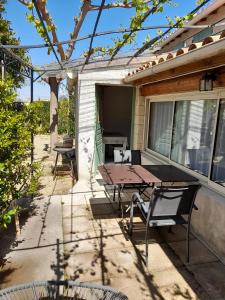 eine Terrasse mit einem Holztisch und Stühlen auf einem Haus in der Unterkunft Chambres d'Hôtes Chez Cécile in Lagnes