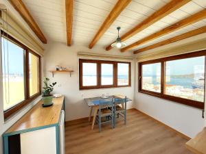 Habitación con mesa y algunas ventanas. en Pefkakia Park, en Ermoupoli