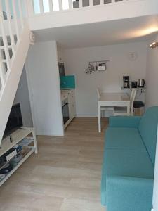 een woonkamer met een blauwe bank en een trap bij Maison de vacances 4 personnes in La Tranche-sur-Mer