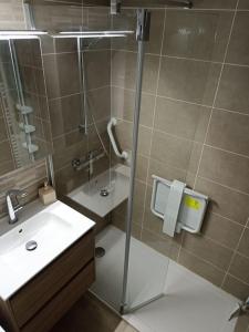 een badkamer met een douche, een wastafel en een glazen deur bij Maison de vacances 4 personnes in La Tranche-sur-Mer