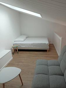 een woonkamer met een bed en een bank bij Maison de vacances 4 personnes in La Tranche-sur-Mer