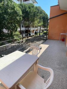 a picnic table and two chairs on a balcony at APPARTAMENTO MARANGA in Lignano Sabbiadoro