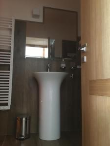 y baño con lavabo blanco y espejo. en GAPO Rooms, en Orta Nova