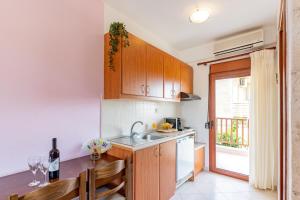 a kitchen with wooden cabinets and a sink and a window at Erifili Kallithea in Kallithea Halkidikis