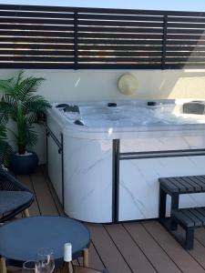 - un bain à remous sur une terrasse avec une table et un banc dans l'établissement Sea view penthouse Private rooftop jacuzzi, à Eilat