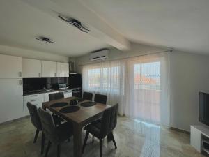 una cucina e una sala da pranzo con tavolo e sedie di Apartmani M&M a Bibinje (Bibigne)