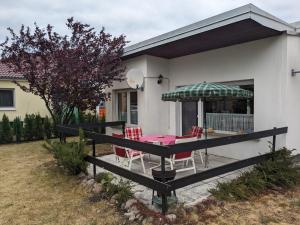 a patio with a table and chairs and an umbrella at Ferienbungalow Kajüte in Koserow