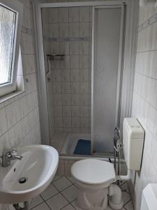 a bathroom with a toilet and a sink and a shower at Ferienbungalow Kajüte in Ostseebad Koserow
