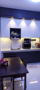 una cucina con tavolo e una cucina con armadi blu di Solace R3 SetiaWalk Pusat Bandar puchong a Puchong