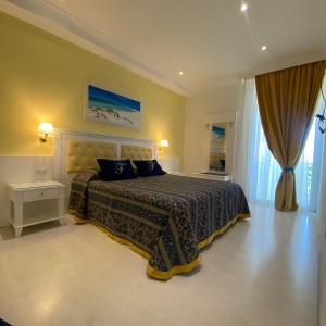 a bedroom with a bed in a room with windows at Falli Exclusive Rooms and Breakfast in Porto Cesareo