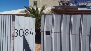 un cartel en una valla delante de una casa en Opal Back House, en Coober Pedy