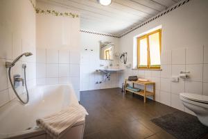 a bathroom with a tub and a toilet and a sink at Pension Gimpl in Siegsdorf