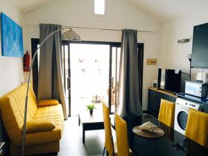een woonkamer met een gele bank en een raam bij CANARY Beach I in Costa Teguise