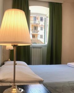 a bedroom with a bed with a lamp and a window at Placa Apartments in Mošćenička Draga