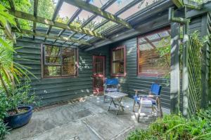 a patio with blue chairs and a pergola at Millton Park Estate in Invercargill