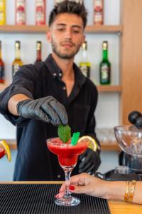 un hombre preparando una bebida en un vaso de martini en Lupia Suites, en Kalkan