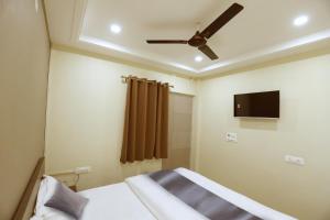 a bedroom with a bed and a ceiling fan at Heaven Hotel in Bareilly