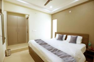 a bedroom with a large bed and a walk in shower at Heaven Hotel in Bareilly