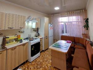 kuchnia i salon z kuchenką i kanapą w obiekcie NUKUS GUEST HOUSE w Nukus