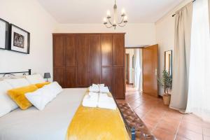 una camera da letto con un grande letto bianco con testiera in legno di Country House nella Winery a Frascati