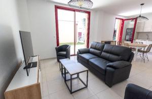 a living room with a couch and a table at Appartement proche du lac centre ville in Soustons