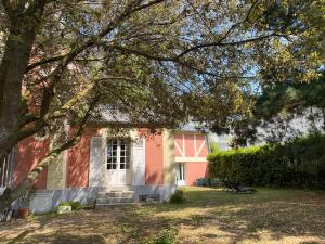 ein rotes Haus mit einem Baum davor in der Unterkunft VILLA LA VISTULE in Dinard