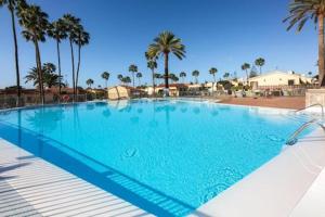duży błękitny basen z palmami w obiekcie Bungalow Santa Fe next to pool w mieście San Bartolomé