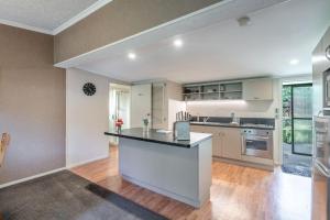 an empty kitchen with a large island in the middle at Millton Park Estate in Invercargill