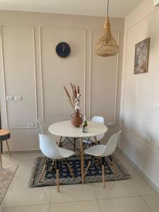 a dining room with a white table and chairs at Sea view penthouse Private rooftop jacuzzi in Eilat