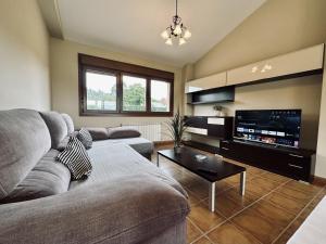 ein Wohnzimmer mit einem Sofa und einem Flachbild-TV in der Unterkunft El Magnolio - 7802 in Castillo