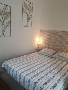 a bedroom with a bed with a striped comforter at A 500 m de la plage, tout confort avec wifi in Le Barcarès