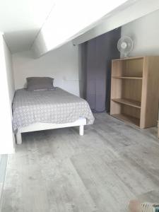 ein Schlafzimmer mit einem Bett in einem weißen Zimmer in der Unterkunft A 500 m de la plage, tout confort avec wifi in Le Barcarès
